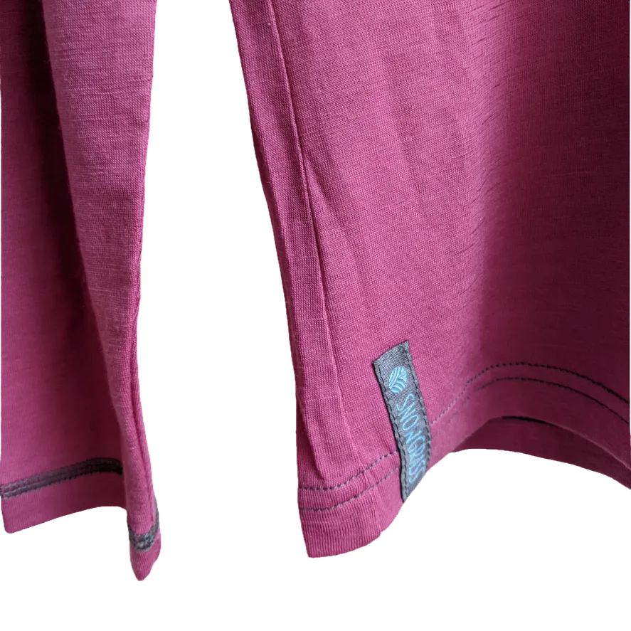 Close-up of a pink merino top with the label on a white background
