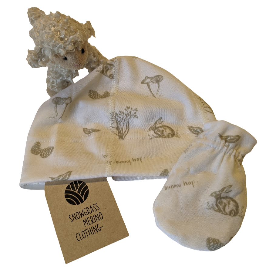Merino Wool Baby Gift Set of Hat and Mittens with teddy bear and tag on a white background
