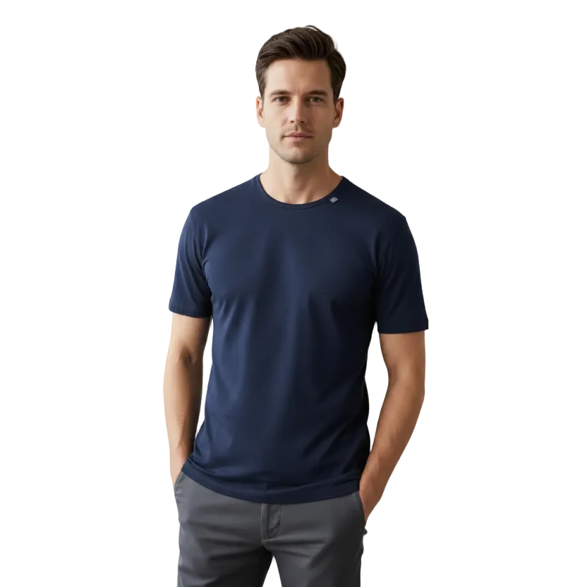 A man wearing a navy blue merino wool crew-neck t-shirt and gray pants, standing against a neutral gray studio background.
