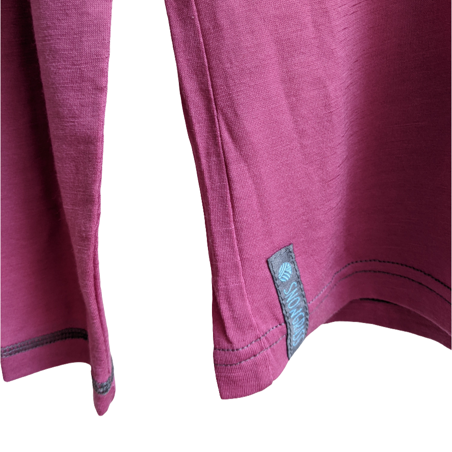 Close-up of a pink merino top with the label on a white background